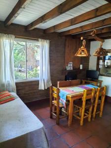 a dining room with a table and chairs and a window at Cabañas Blumenhaus in Villa Ventana +21 photos