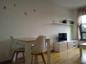 een eetkamer met een tafel, stoelen en een televisie bij Apartamento Rimiño in Salvatierra de Miño