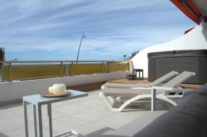 a balcony with two chairs and a table on a roof at Seafront Playa La Arena in Puerto de Santiago