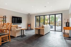a living room with couches and a tv and a fireplace at Holly Tree Cottage in Dornoch