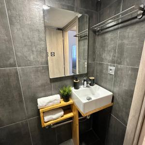 a bathroom with a sink and a mirror at R&T Apartments in Kallithea Halkidikis