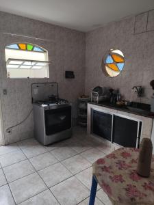 eine Küche mit Herd, Spüle und Spiegel in der Unterkunft Lar da prainha in Arraial do Cabo
