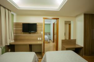 a hotel room with two beds and a television at Hotel Prata Villaggio in Nova Prata +116 photos