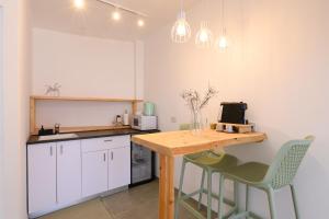 a kitchen with a wooden table and two chairs at נקודה בנוף - וילה פרטית in Had Nes