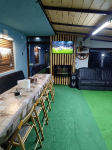 a room with a long table and a television at Casă de vacanţă ,,La Vălucu" in Curtea de Argeş