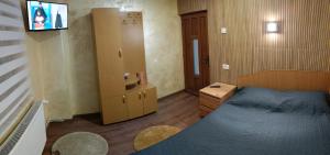 a small room with a bed and a tv in it at Casă de vacanţă ,,La Vălucu" in Curtea de Argeş