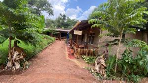 a house with a dirt road in front of it at Alkebulan Farm House in Moshi