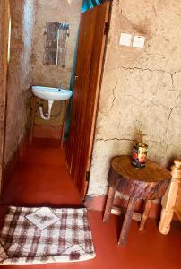 een kleine badkamer met een wastafel en een tafel bij Alkebulan Farm House in Moshi