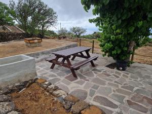 a wooden picnic table sitting on a stone patio at Casa Rural Lomo Lugo in Isora +2 photos
