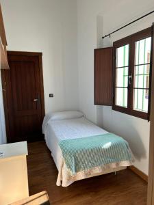 una piccola camera da letto con un letto e una finestra di Apartamentos Gerena 5 B primero a Gerena 1 altra foto