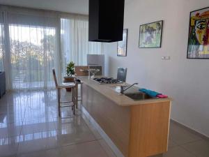 a kitchen with a counter with a sink and a stove at Melrose beach apartment in Tamaris