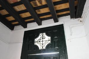 una puerta negra en una habitación con techo de madera en Apartamento Fatima, en Conil de la Frontera