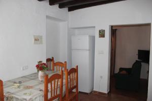 cocina con mesa, sillas y nevera en Apartamento Fatima, en Conil de la Frontera