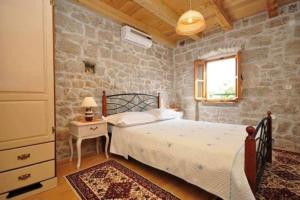 a bedroom with a bed and a stone wall at Stone house in Brela
