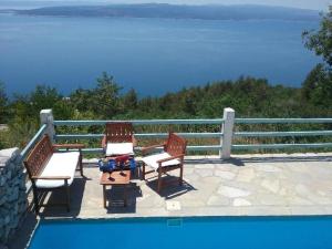 two chairs sitting on a patio overlooking the water at Stone house in Brela