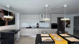 een keuken met witte kasten en een tafel met borden erop bij apartament in Marbella