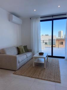 a living room with a couch and a coffee table at Swieqi Malaika New Penthouse 10 in Is-Swieqi