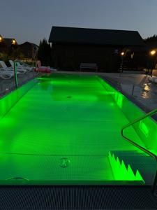 a pool with green illumination in a parking lot at Osada Lekranka in Kopań