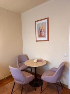 a waiting room with a table and chairs and a picture at Savaria Kuckó in Szombathely