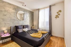 a bedroom with a black bed and a mirror at Le Cocon - Cinéma in Gentilly