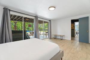 a bedroom with a white bed and a large window at 5br Getaway Near Plaza Dist Patio & Lounge #mr in Warr Acres