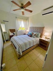 a bedroom with a bed and a ceiling fan at Bohemian Townhouse Palm Beach Aruba in Palm-Eagle Beach