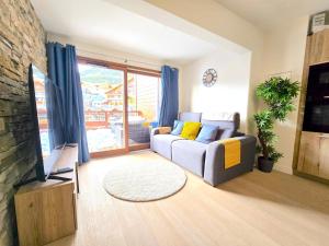 a living room with a couch and a tv at Incroyable T2 neuf et spacieux - Garage privé in L'Alpe-d'Huez