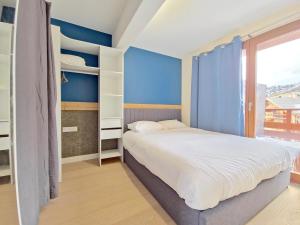 a small bedroom with a bed and a window at Incroyable T2 neuf et spacieux - Garage privé in L'Alpe-d'Huez