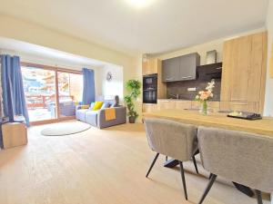 a kitchen and living room with a table and chairs at Incroyable T2 neuf et spacieux - Garage privé in L'Alpe-d'Huez