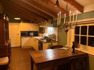 a kitchen with a wooden table in a room at B&B Het Gasthuys in Amerongen