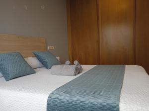een slaapkamer met een groot bed met blauwe kussens bij Apartamento Rimiño in Salvatierra de Miño
