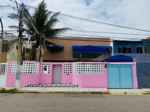 a pink and blue house with a fence at Guest House Rosa do Mar in Olinda