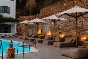 a patio with couches and umbrellas next to a pool at Gianemma Luxury Apartments in Mylopotas +29 photos