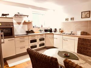 a kitchen with white cabinets and a table with chairs at Wohnung im Haus Annabelle Tiefparterre in Weeze
