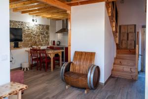 a living room with a table and a chair at Adega dos Avós - Casa completa in Alcobaça