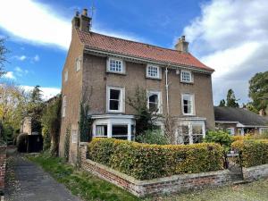 una grande casa di mattoni con una siepe di fronte di Crofton Dye House a Yarm