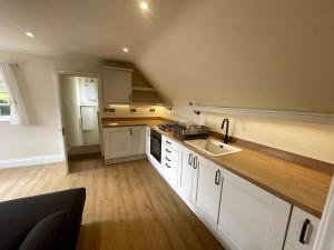 una cucina con mobili bianchi e un piano di lavoro in legno di Crofton Dye House a Yarm