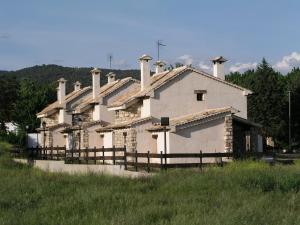 a building with multiple chimneys on it in a field at Casa Rural Nelia in Villalba de la Sierra
