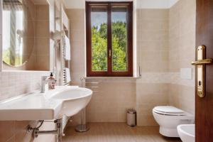 Un baño con lavabo, inodoro y ventana. en Achilla 1 appartamenti, en Torri del Benaco 16 fotos más
