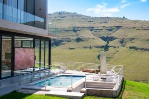 a house with a swimming pool and a mountain at The Curve in Dullstroom
