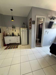 a kitchen with a sink and a refrigerator in a room at Loft funcional no centro! in Foz do Iguaçu
