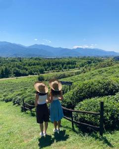 deux jeunes filles debout sur une colline donnant sur les montagnes dans l'établissement Taba tea house & tea garden, à Ozurgetʼi
