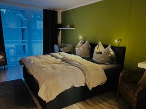 a bedroom with a large bed with pillows on it at Pension Osthoff in Wülfrath
