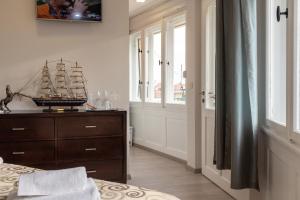 a bedroom with a wooden dresser with a model ship on it at Queen Teuta Luxury Rooms Split in Split