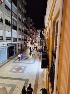 un grupo de personas caminando por una calle por la noche en Apartamentos La Bola 94, en Ronda