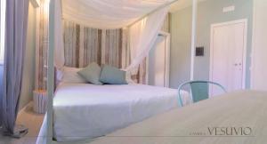 a bedroom with a white bed with a canopy at B&b Torre del Greco in Torre del Greco