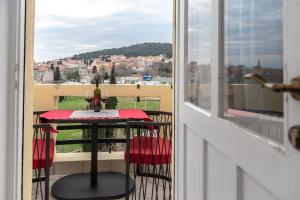 a balcony with a table with a view of a city at Queen Teuta Luxury Rooms Split in Split