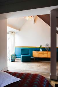 a bedroom with a blue couch and a table at Appartements Au-Dessus Du... in Strasbourg