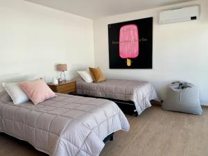 a bedroom with two beds and a picture of a pink car at Casa entre pinos in La Florida