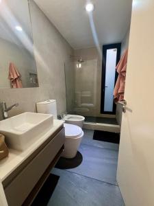 a bathroom with a sink and a toilet and a mirror at Casa entre pinos in La Florida
